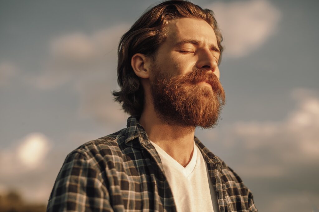 Calm man meditating in sunny summer day