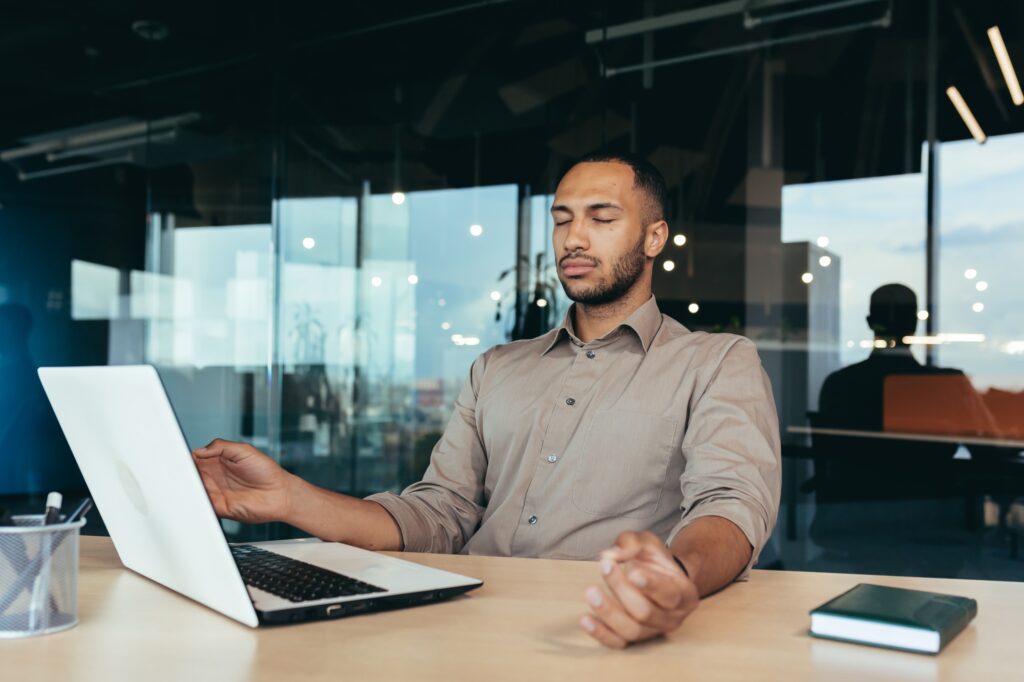 Successful businessman working inside modern office building, man meditating